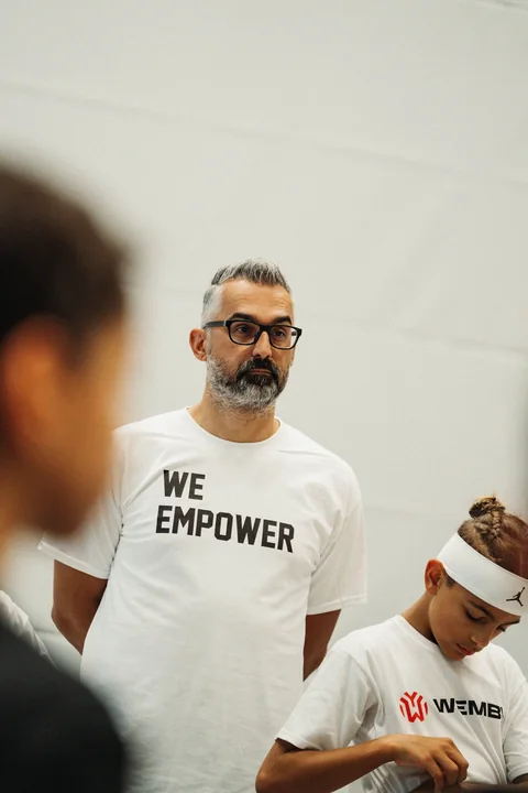 Trainer im „We Empower“-Shirt