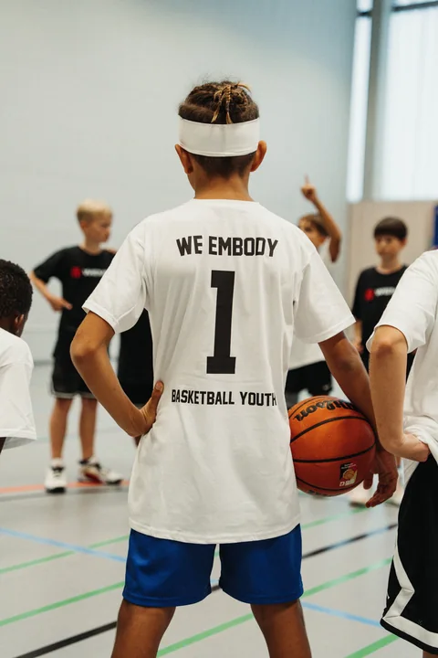 Spieler im „We Embody 1“-Shirt mit Ball